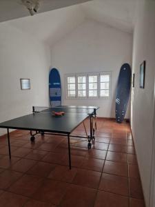 a ping pong table in a room with two surfboards at Casa Beatriz in Famara