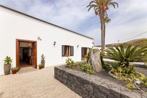 a white building with a palm tree in front of it at Refugio del Volcán by Tropical Host in Uga