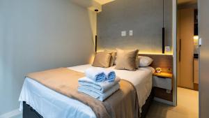 una camera da letto con un letto con asciugamani sopra di Estúdios modernos no Campo Elísios - Próximo a estação República a San Paolo