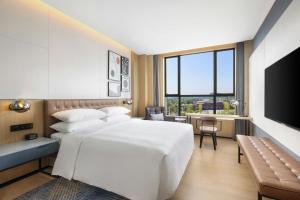 a hotel room with a bed and a television at Four Points by Sheraton Ji’an in Ji'an +30 photos
