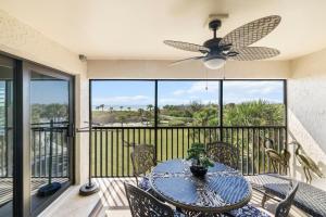 a patio with a table and a ceiling fan at Sandpiper Beach 205 in Ybel