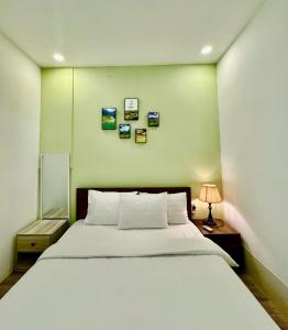 a bedroom with a bed and a wall with pictures at Crab Bui Vien Homestay in Ho Chi Minh City