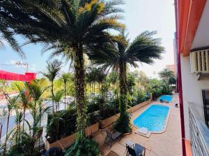 a balcony with palm trees and a swimming pool at MBC Condotel Maikhao beach in Mai Khao Beach