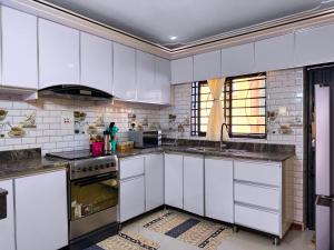 a kitchen with white cabinets and a stove at Munyonyo Haven in Kampala
