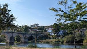a bridge over a river with houses and trees at In the heart of Ponte da Barca, cozy apartment in Ponte da Barca