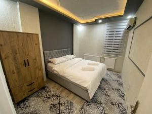 ein kleines Schlafzimmer mit einem Bett und einem Holzschrank in der Unterkunft Suit 4 in Bursa