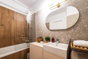 Maison Lumière - A modern Designer Apartment in Central Bucharest في بوخارست: حمام مزود بحوض ومِرآة +27 صورة