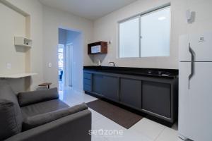 a kitchen with a black counter and a refrigerator at Apto 1 Quarto a 650 m da Praia FAH0205 in Florianópolis