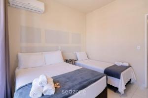 two beds in a small room with towels on them at Apto 1 Quarto a 650 m da Praia FAH0205 in Florianópolis