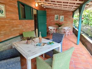 Saint-PierreLa Case à Lucie的露台上的木桌和椅子
