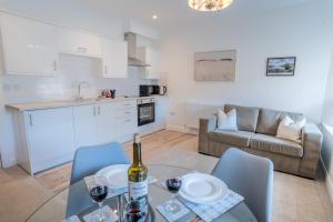 ウルバーストンにあるLonsdale House Boutique Apartmentsのキッチン、リビングルーム(ワイン1本とテーブル付)