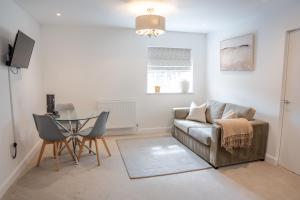 a living room with a couch and a table at Lonsdale House Boutique Apartments in Ulverston