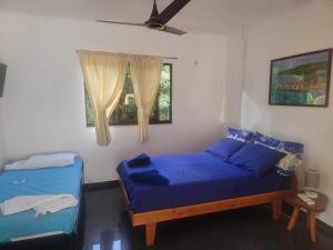 a bedroom with two beds and a window at Papaya Guesthouse in Mahe
