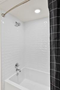 a white bathroom with a shower and a sink at Bright Studio on Sunset Blvd Pool, Parking, Gym in Los Angeles +9 photos