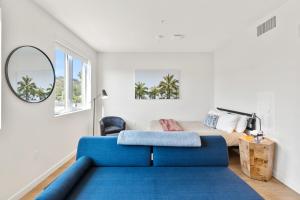 a living room with a blue couch and a bed at Bright Studio on Sunset Blvd Pool, Parking, Gym in Los Angeles