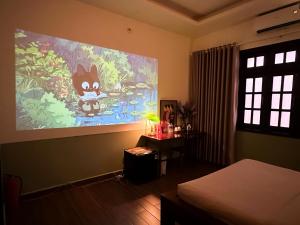 a bedroom with a painting of a cat on the wall at Charming A Little Saigon Apartment - Heart of Vibrant District 1 in Ho Chi Minh City