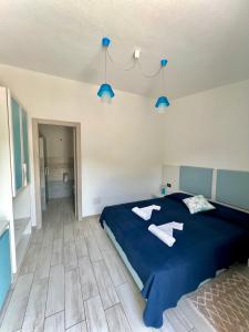 カーラゴノネにあるHotel Pranos Turismo Rurale Cala Gononeの青いベッドと2枚のタオルが置かれた寝室