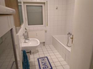 a bathroom with a sink and a bath tub and a sink at Appartement in Freudenburg
