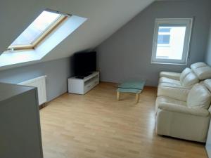 a living room with a couch and a tv at Appartement in Freudenburg