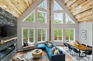 a living room with a fireplace and a blue couch and a table at New The Chaletresorthot Tubgameroomfirepit in Massanutten