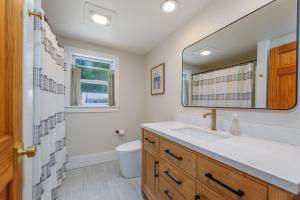 ケープ・メイにあるModern Coastal Farmhouseの洗面台と鏡のあるバスルーム +46枚の写真