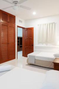 - une chambre avec 2 lits et une porte en bois dans l'établissement Hotel Vista Caribe Villas, à Playa del Carmen