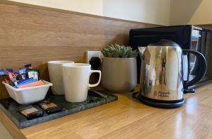 a coffee maker sitting on a counter next to cups at Sutton Guest House in Birmingham