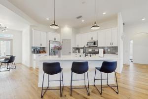 a kitchen with white cabinets and blue bar stools at Casa Sereno in Palm Desert