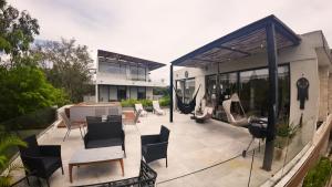 une maison avec un patio avec des chaises et une table dans l'établissement Boho Chic Loft- Stunning Terrace in Central Tulum, à Tulum