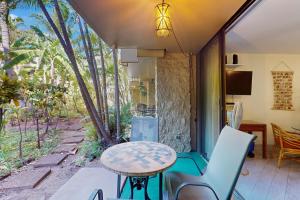 Un patio con una mesa y sillas en un porche. en Paki Maui 112, en Honokowai