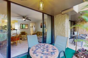 patio con mesa y sillas y sala de estar. en Paki Maui 112, en Honokowai