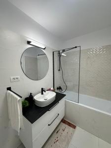 a white bathroom with a sink and a mirror at Nest & Rest Apartment Fast Wi-Fi Free Parking in Braşov