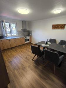 a living room with a table and chairs and a kitchen at Ferienwohnung Schelklewiese in Baiersbronn +9 photos