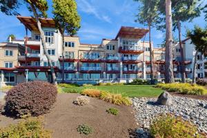 un edificio de apartamentos con árboles y un jardín en Birch Bay Getaway, en Birch Bay