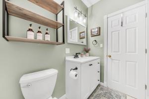 a bathroom with a white toilet and a sink at Cozy Buffalo Getaway Minutes to Downtown & Bills Stadium in Buffalo +11 photos