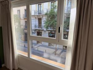 a window with a view of a city street at Groma Rooms in Zaragoza
