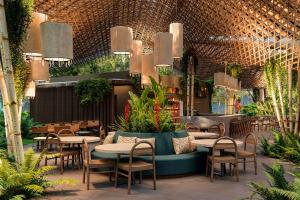 a restaurant with tables and chairs and plants at Santa Lucia Jungle Hacienda, Autograph Collection in Tarcoles +10 photos