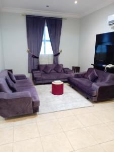 a living room with two couches and a television at أجنحة أجواء إيلاف الاولى in Taif