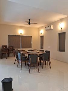 ein Esszimmer mit einem Tisch, Stühlen und einer Tafel in der Unterkunft Kalhaar Blues And Greens Premium Villa in Ahmedabad