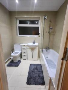 Un baño con bañera, lavabo e inodoro. en Comfy 3-Bed House - Sleeps 6 & Free Parking, en Tilbury