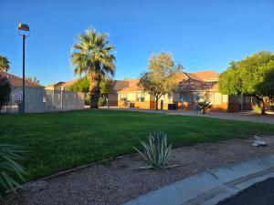 a yard with a green lawn with houses at Mesquite Nevada Vacation Rental - Ground Level and double car garage in Mesquite