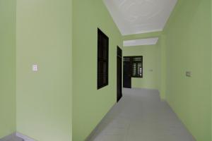 ein Flur mit grün-weißen Wänden und weißem Boden in der Unterkunft SPOT ON Hotel The Baithak & Restaurant in Etāwah