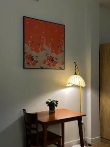 une table avec une lampe et une plante en pot sur un mur dans l'établissement Saigon Downtown Home - 100m to Nguyen Hue Walking Street, à Hô-Chi-Minh-Ville