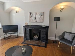 a living room with a fireplace and a chair at Lovely 2 Bedroom Getaway in Newcastle upon Tyne