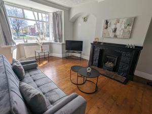 a living room with a couch and a fireplace at Lovely 2 Bedroom Getaway in Newcastle upon Tyne