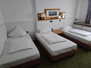 a room with three beds and a mirror on the wall at Yeti Hotel Saarbrücken in Saarbrücken