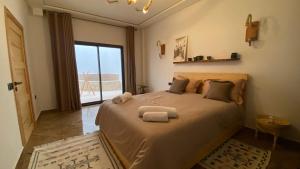 a bedroom with a large bed with towels on it at Tamrazen retreat in Tamraght Ouzdar