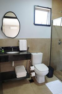 a bathroom with a toilet and a sink and a mirror at Pousada Vila Caminito in Brotas +48 photos