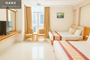 a hotel room with two beds and a tv at S79 Happy 7 Ly Thai To Street in Ho Chi Minh City