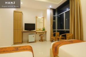 a hotel room with two beds and a television at S79 Happy 7 Ly Thai To Street in Ho Chi Minh City